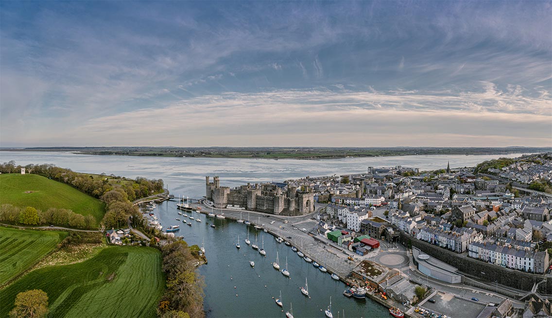 Panoramic view of Caernarfon Castle and the slate quay and harbour. Spring views.